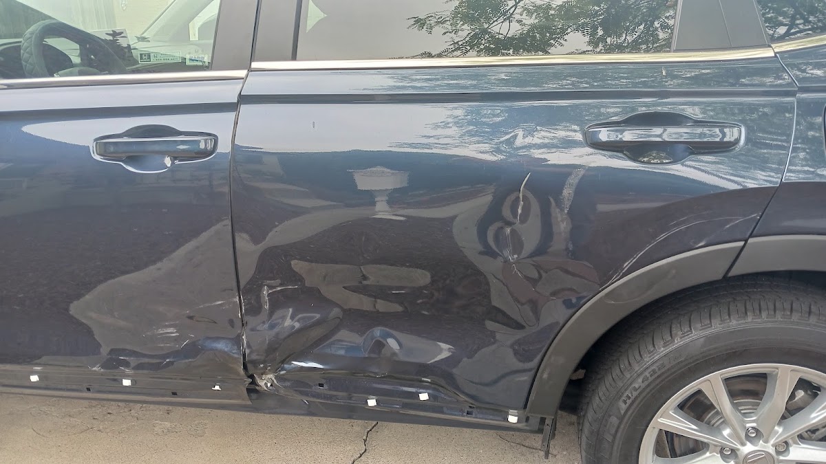 Gray SUV with door and panel collision damage